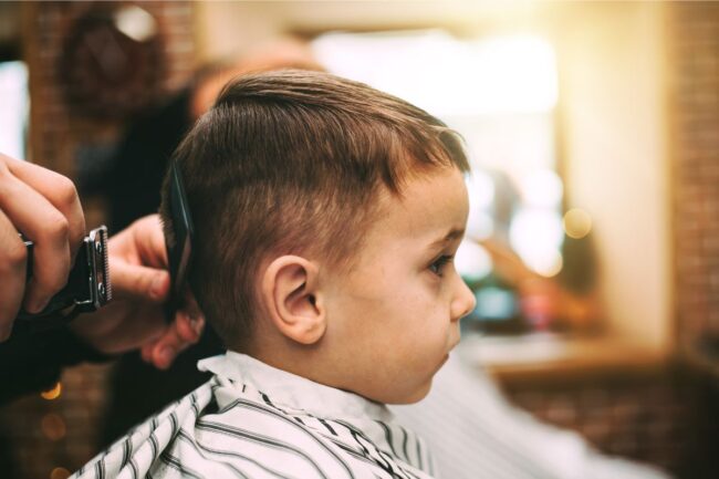 Smiling child getting a haircut at a kid-friendly salon