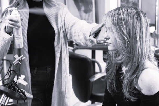 Stylist creating soft layers for fine hair to add natural volume at a luxury salon in Westchester.