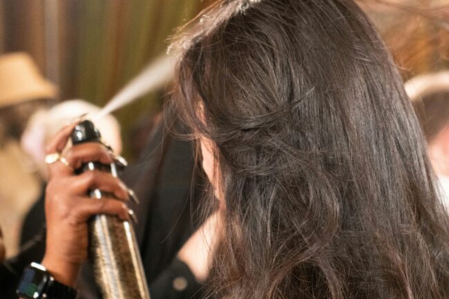 Stylist hand-painting dimensional brunette hair color on a client at a luxury boutique salon in Westchester.